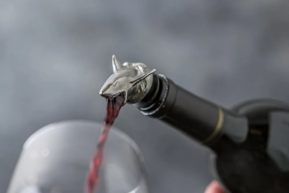 Shark wine pourer pouring red wine into a glass